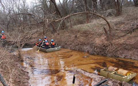 ER Service boat with team members in it on a river where oil has leaked 