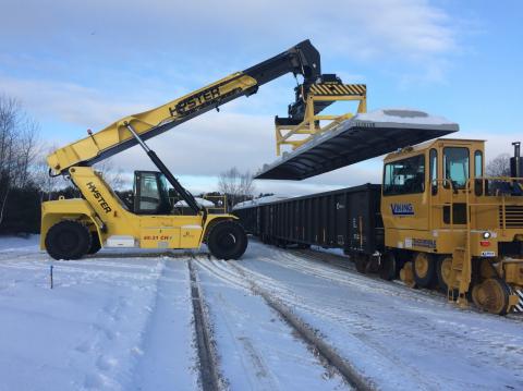 reach stacker lifting up the top of the container